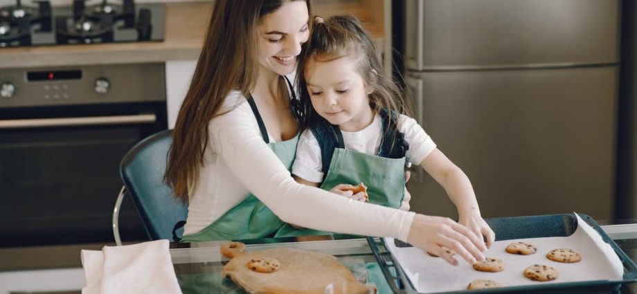 A mother and daughter bonding while baking cookies in a cozy kitchen setting.