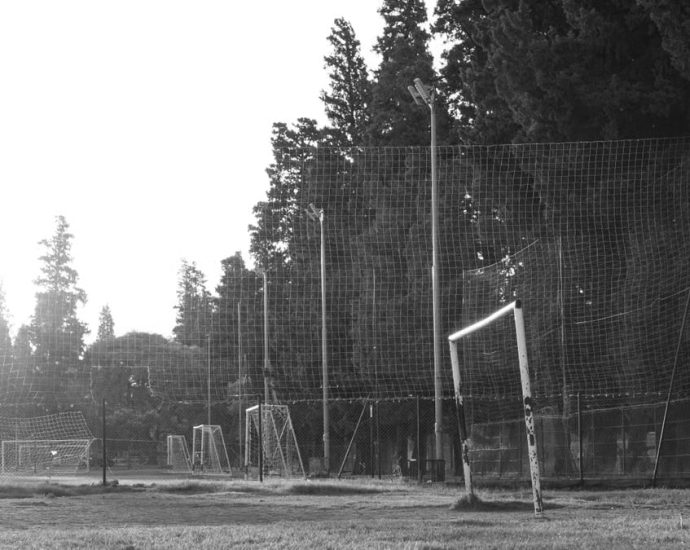 Black and white photo of a rustic football field in Córdoba, Argentina at sunrise.