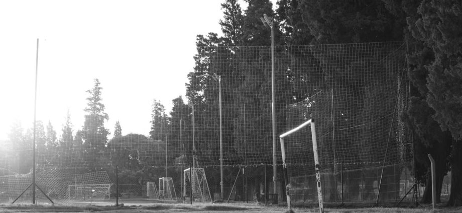 Black and white photo of a rustic football field in Córdoba, Argentina at sunrise.